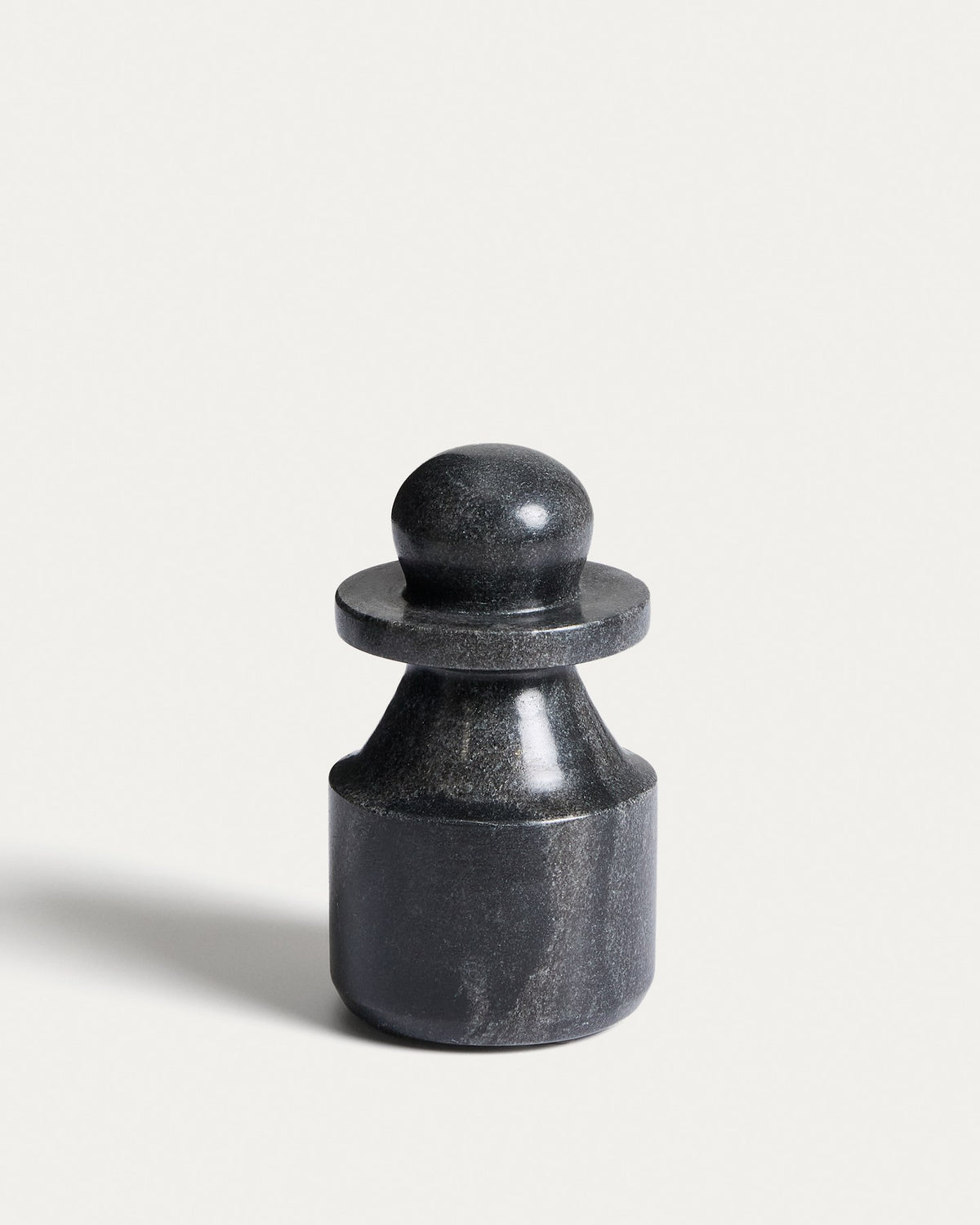 Kleine Skulptur aus grauem Marmor mit glatter Oberfläche, kompakte Form, Höhe 15 cm, Breite und Tiefe je 9 cm, natürliche Maserung sichtbar.