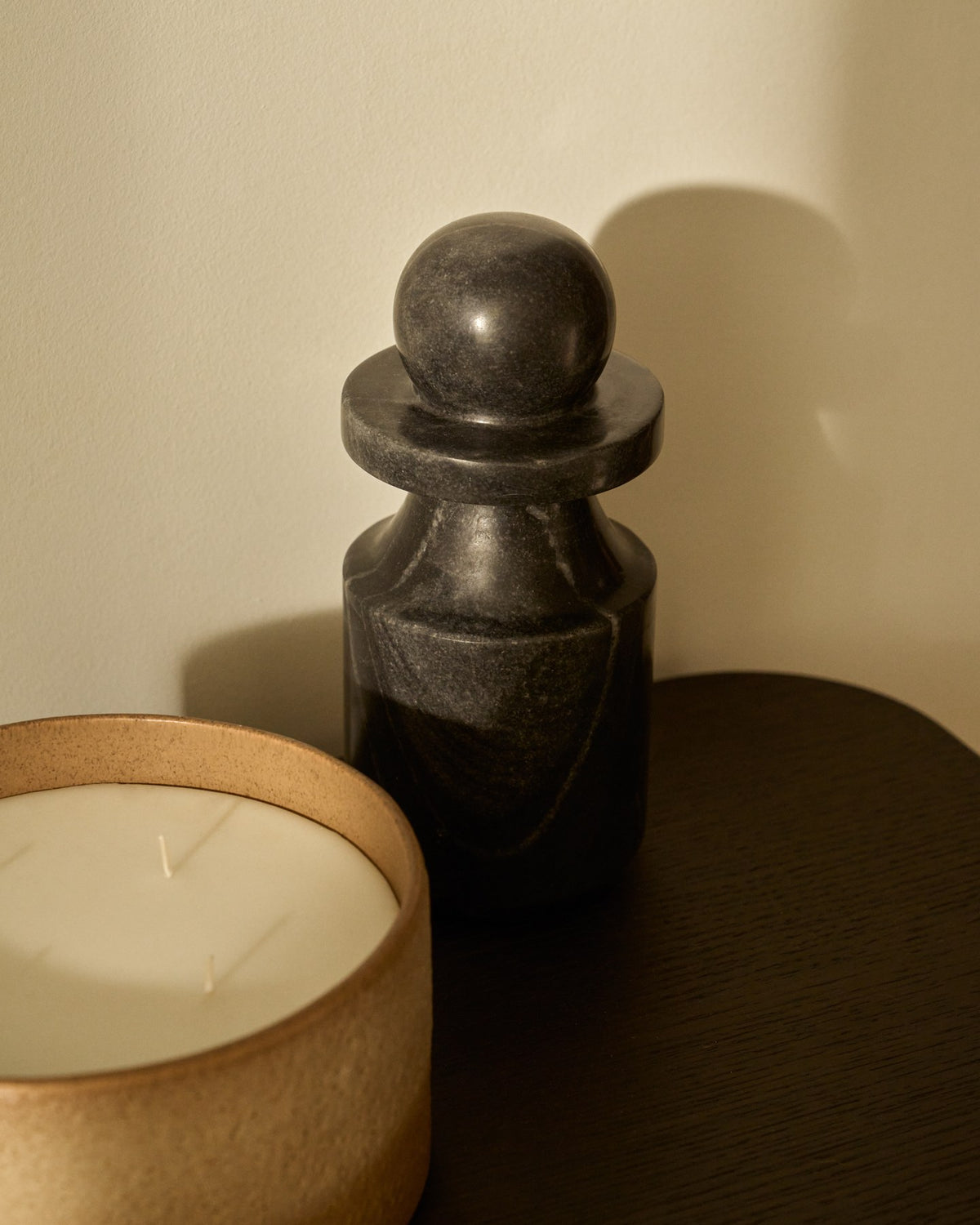 Kleine Skulptur aus grauem Marmor mit glatter Oberfläche, kompakte Form, Höhe 15 cm, Breite und Tiefe je 9 cm, natürliche Maserung sichtbar.