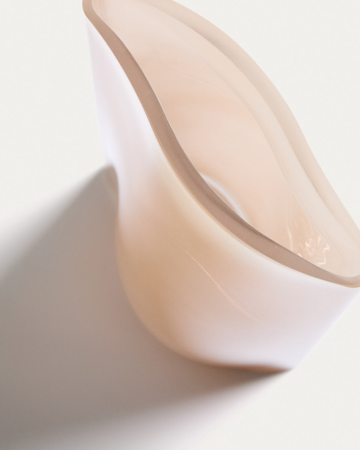 Blassrosa Glas-Vase Ardeni von Kave Home, 28 cm hoch, schlanke Form aus durchgefärbtem Glas mit schmaler Öffnung, freistehend fotografiert.