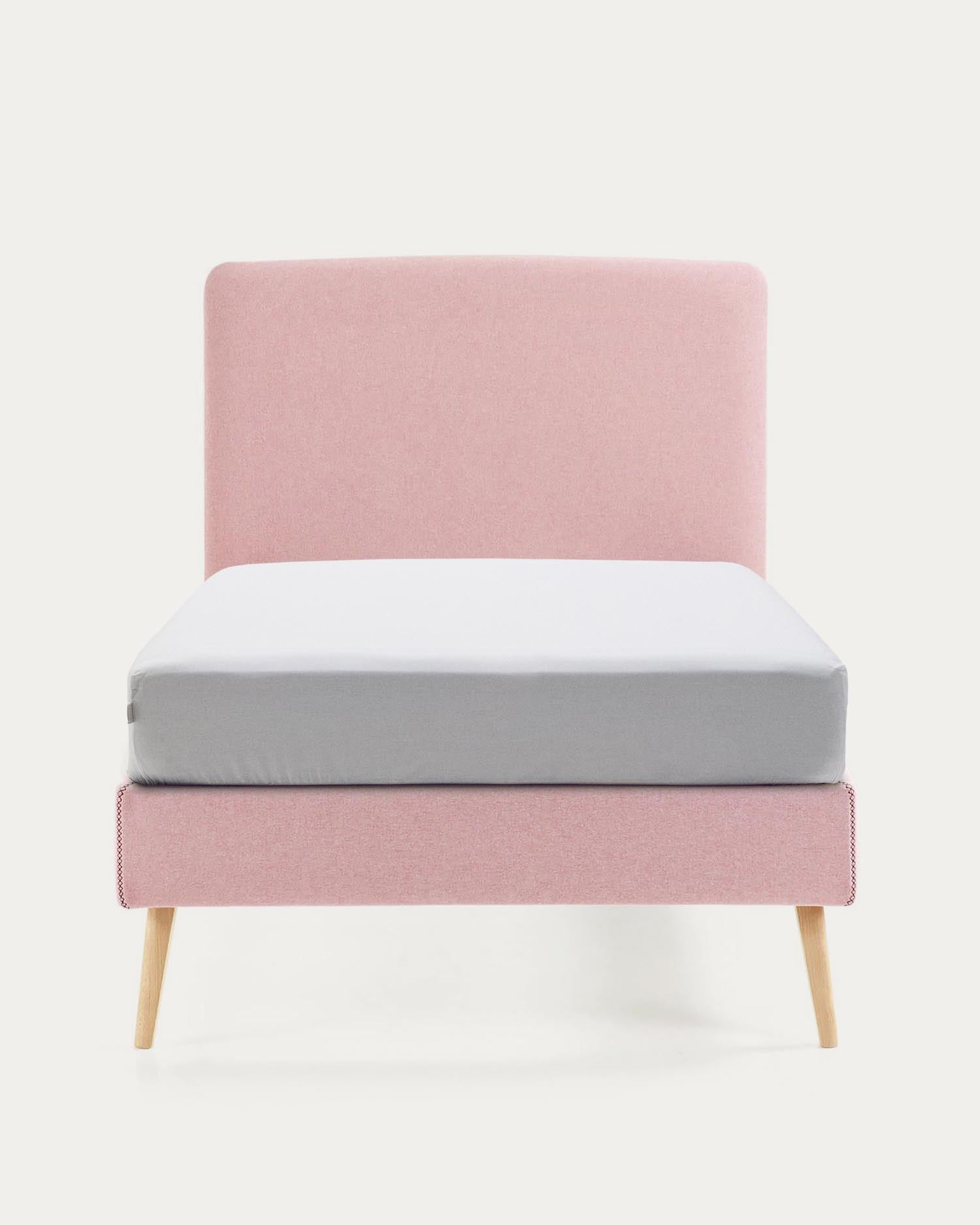 Das Dyla Bett vereint minimalistisches Design mit praktischen Details: rosa Bezug, abnehmbar, auf stabilen Buchenholzbeinen.