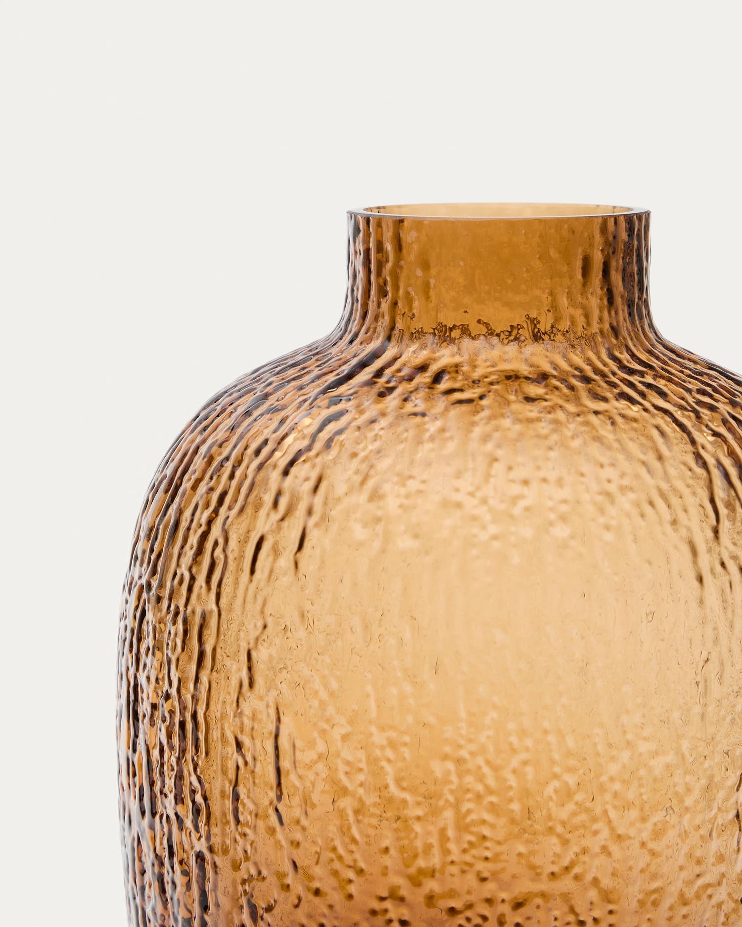 Die Vase Shali aus braunem Glas von Kave Home besticht durch ihr texturiertes Design und fügt sich elegant in jedes Interieur ein.