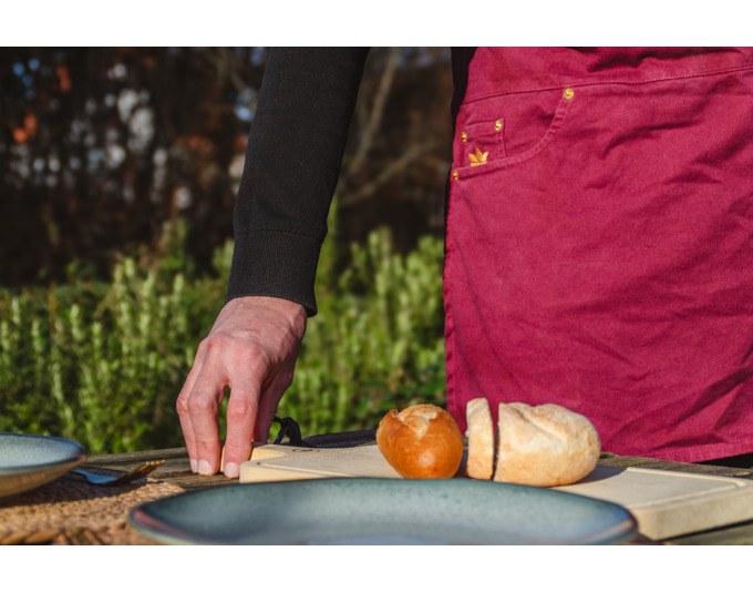 Kochschürze in Aubergine und Braun aus Canvas mit Rundhalsausschnitt, schmalen Seitenteilen, fünf Taschen und Knöpfen zur Anpassung.