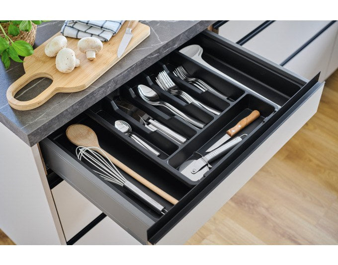 Schwarzer ausziehbarer Besteckkasten aus Kunststoff mit mehreren Fächern für Besteck und Küchenutensilien, Ansicht der geöffneten Schublade.