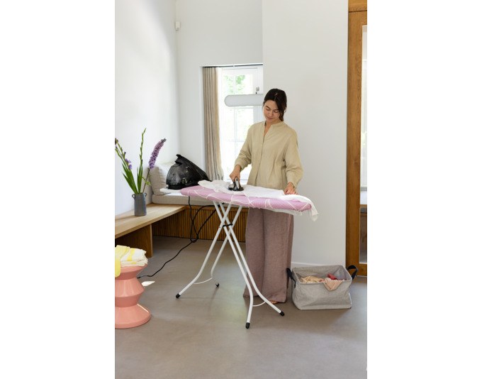 Bügelbrett von BRABANTIA in Lilac Waves mit rosa Bezug, Metall-Dampfbügeleisenablage und Stahlrohr-Vierfussrahmen, Grösse 124x45 cm.