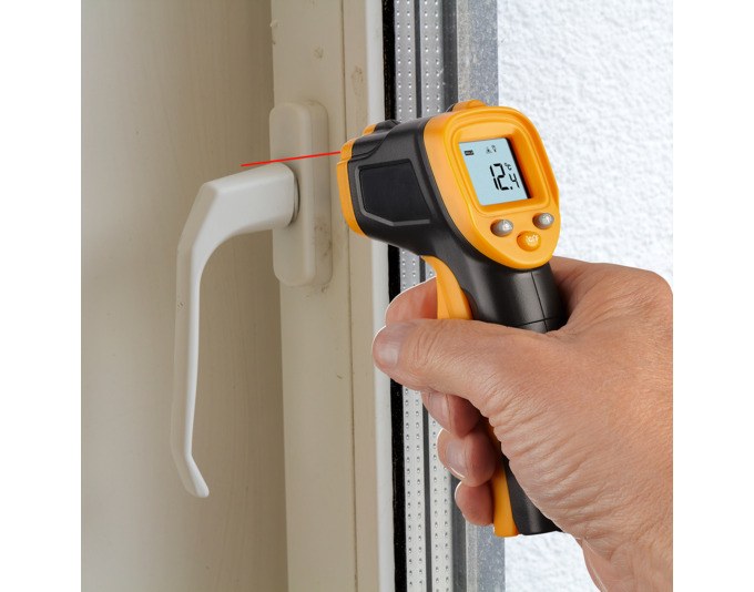 Orange-schwarzes Infrarot-Thermometer TFA Ray Light mit beleuchtetem Display, Auslöser und integriertem Laservisier für punktgenaue Messungen.