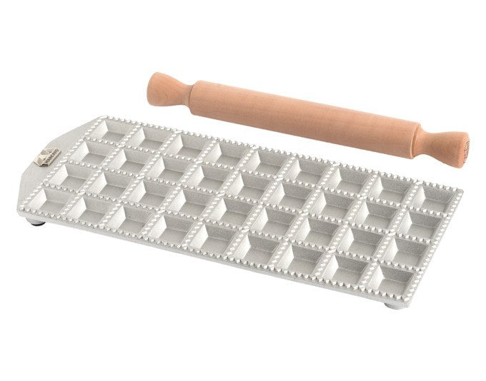 Ravioliform aus Aluminium-Druckguss mit 36 quadratischen Vertiefungen und beiliegendem Nudelholz aus Massivholz, Farbe Silber und Braun.