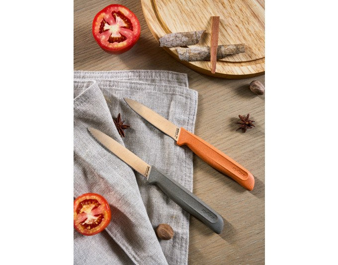 Zwei Küchenmesser mit Edelstahlklingen, eines glatt, eines mit Wellenschliff, Griffe aus grau-orangem Weizenstroh, mit Klingenschutz.