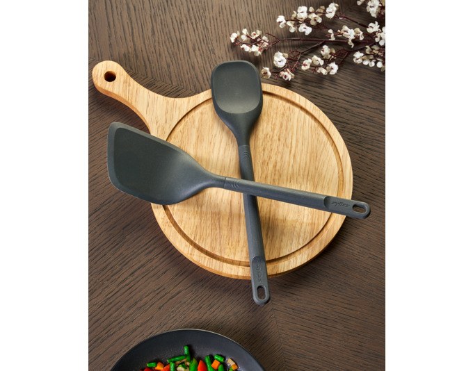 Zweiteiliges ZYLISS Küchenhelfer-Set in Grau: Spatellöffel mit Silikonkopf und abgewinkelter Pfannenwender, Griffe aus Weizenstrohmaterial.