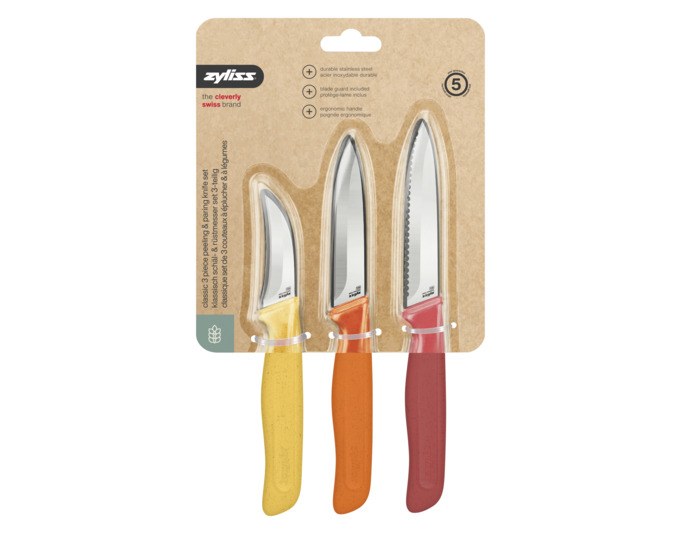 Drei ZYLISS Rüstmesser mit Edelstahlklingen in Orange, Rot und Gelb, ergonomische Griffe aus Weizenstrohmaterial, mit Klingenschutz.