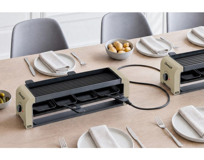 Tischgrill STÖCKLI CheeseGrill 4 Connect in Ivory Gold mit wendbarer Aluguss-Grillplatte, vier Pfännchen und Kunststoffspachteln.
