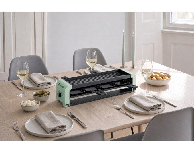 Mint grüner STÖCKLI CheeseGrill 4 Connect mit vier antihaftbeschichteten Pfännchen und wendbarer Aluguss-Grillplatte auf hellem Hintergrund.