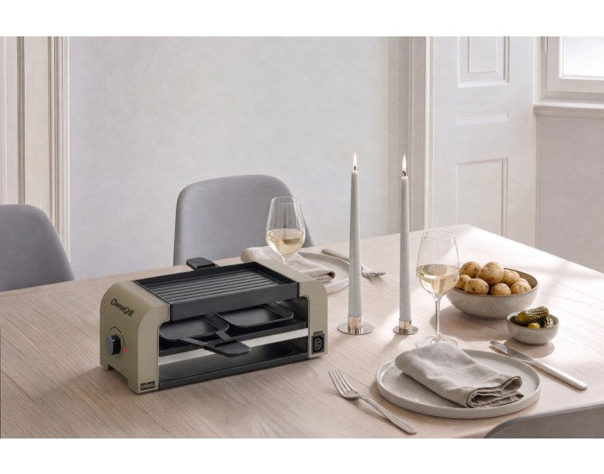 Tischgrill STÖCKLI CheeseGrill 2 Connect in Ivory Gold mit zwei Pfännchen, Wende-Grillplatte und Parkdeck auf hellem Hintergrund.