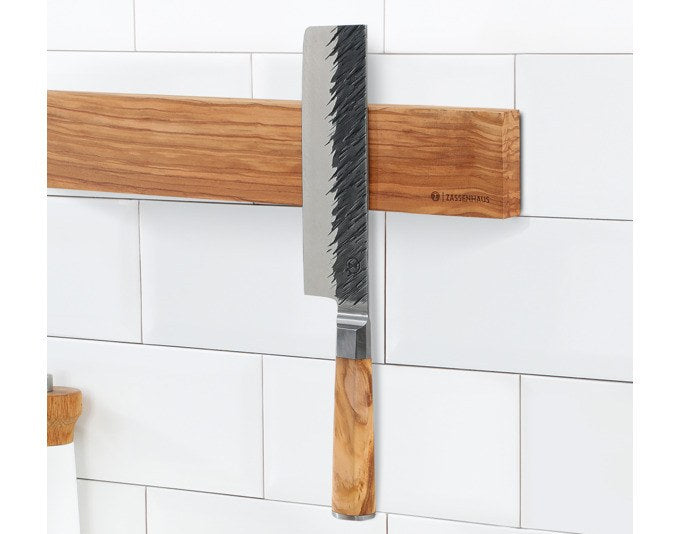 Braune Magnetleiste aus Echtholz mit individueller Maserung, 40 cm lang, an der Wand montiert, mit fünf Küchenmessern befestigt.