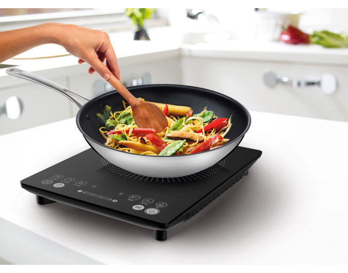 Schwarze TEFAL Induktionsplatte IH2108 mit digitalem Display und Bedienfeld, flache Bauform, auf heller Arbeitsfläche platziert.
