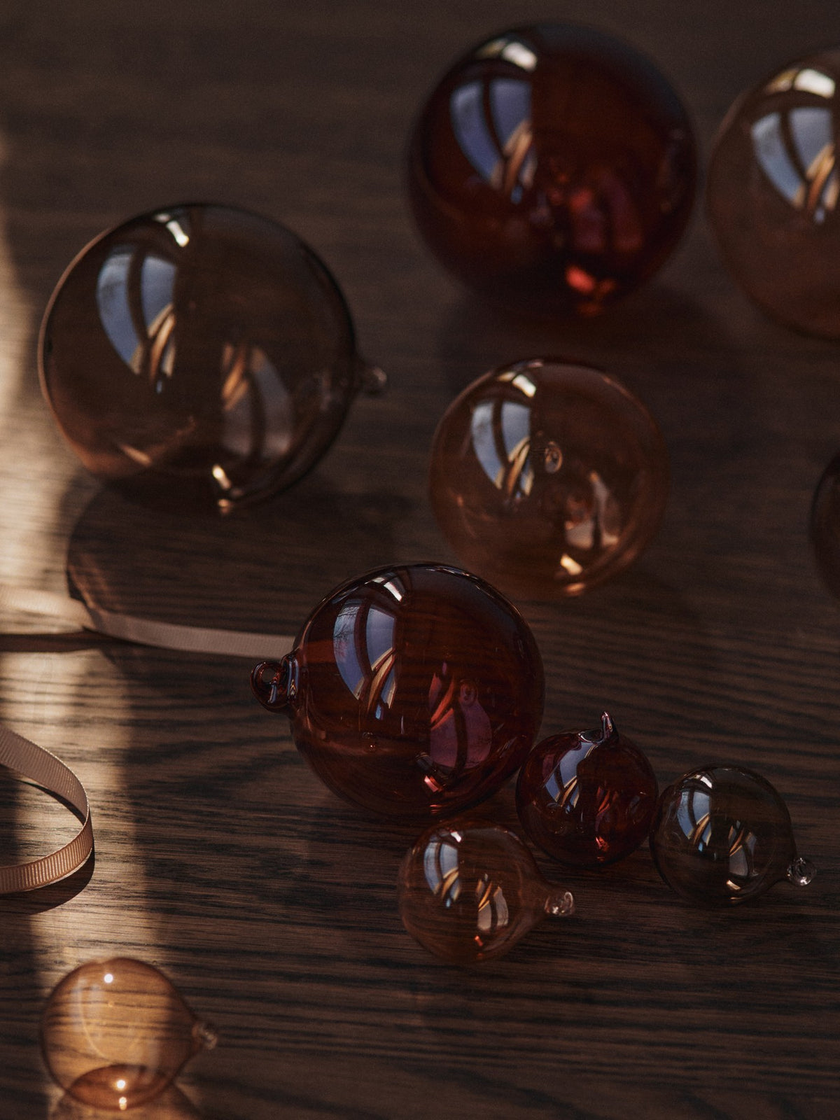 Drei kleine Glaskugeln in Rosenfarbig Opak aus mundgeblasenem Glas, mit cremefarbenem Polyesterband zum Aufhängen, als Weihnachtsornament.