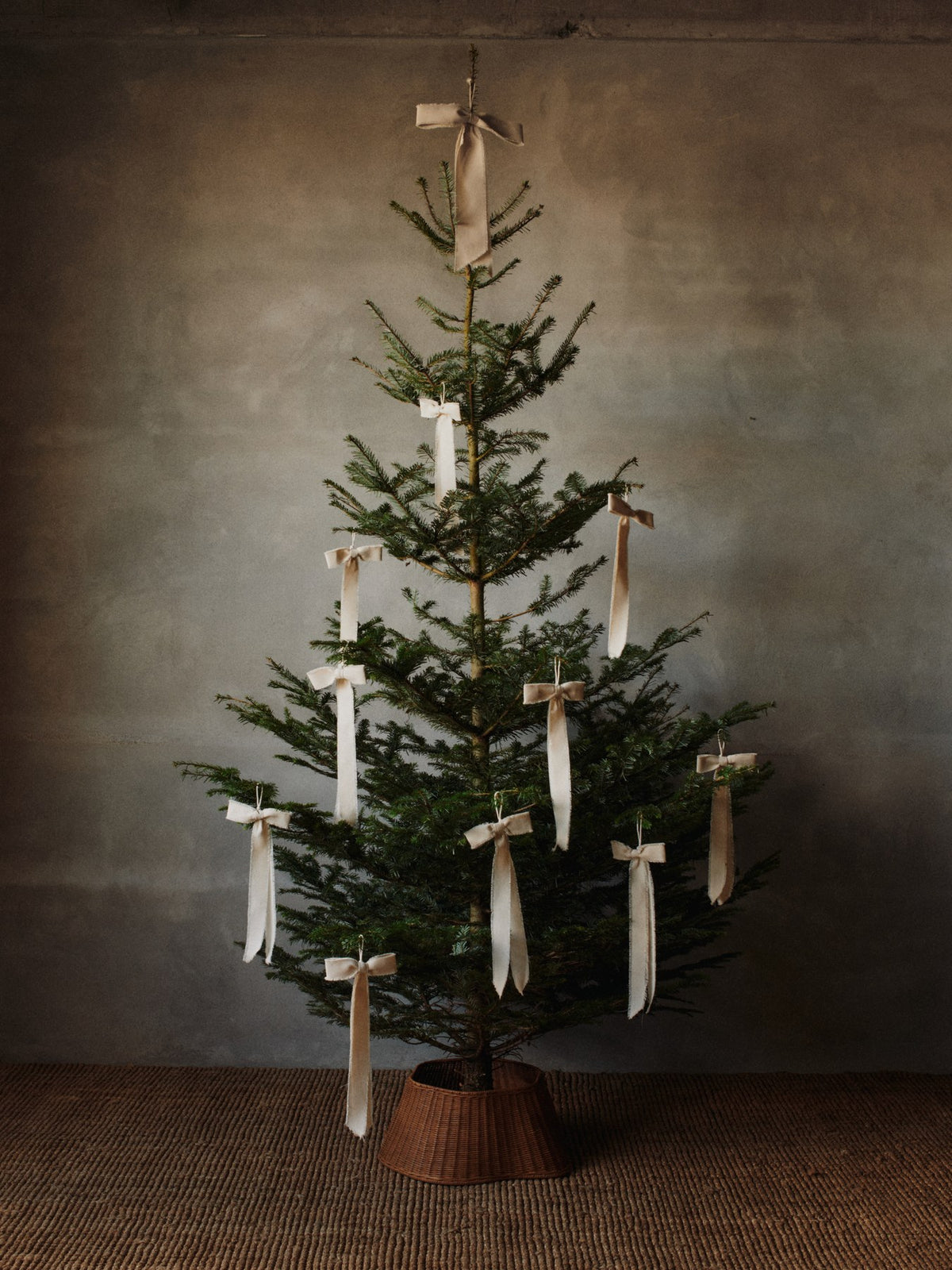 Zweiteiliger Baumrock aus handgeflochtenem Rattan mit Eisenstruktur im Inneren, natürliche Farbe, rund um den Weihnachtsbaum drapiert.