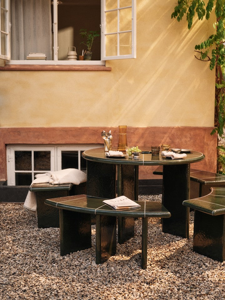 Moderner Deya Gartentisch Ø120 in edlem Dunkelgrün von Ferm Living, perfekt für entspannte Stunden im Freien und gesellige Runden.
