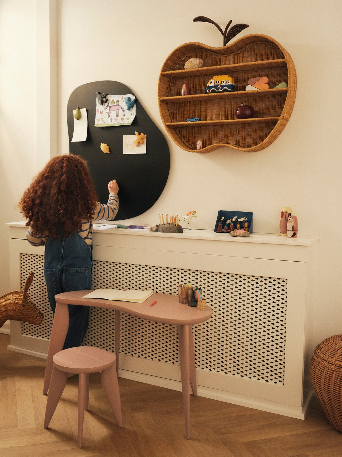 Feve Kinderschreibtisch von Ferm Living aus massiver Esche in Rose, mit asymmetrischer Tischplatte und schlanken elliptischen Beinen.