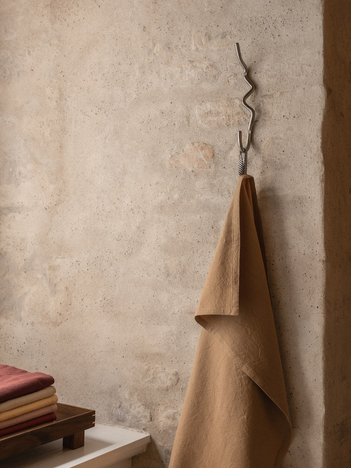 Curvature Haken von Ferm Living aus Edelstahl, handgefertigt mit geschwungener Form, zum Aufhängen von Handtüchern und Kleidung geeignet.