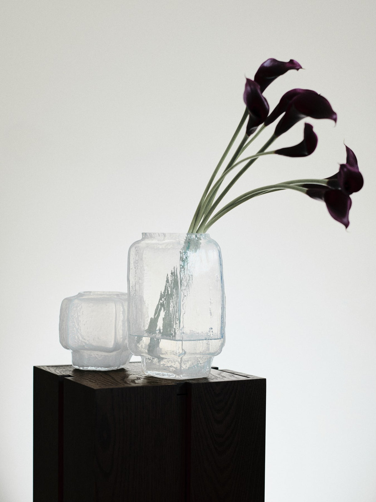Schwarze Mokuri Vase aus mundgeblasenem, recyceltem Glas mit facettierter Oberfläche und vertikalen Linien, Höhe 15 cm.