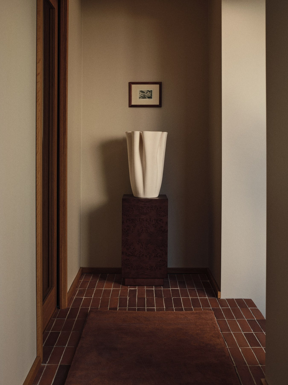 Burl Beistelltisch von Ferm Living mit dunkel gebeiztem Wurzelholzfurnier auf MDF-Kern, sockelartige Form mit verstecktem Stauraum.