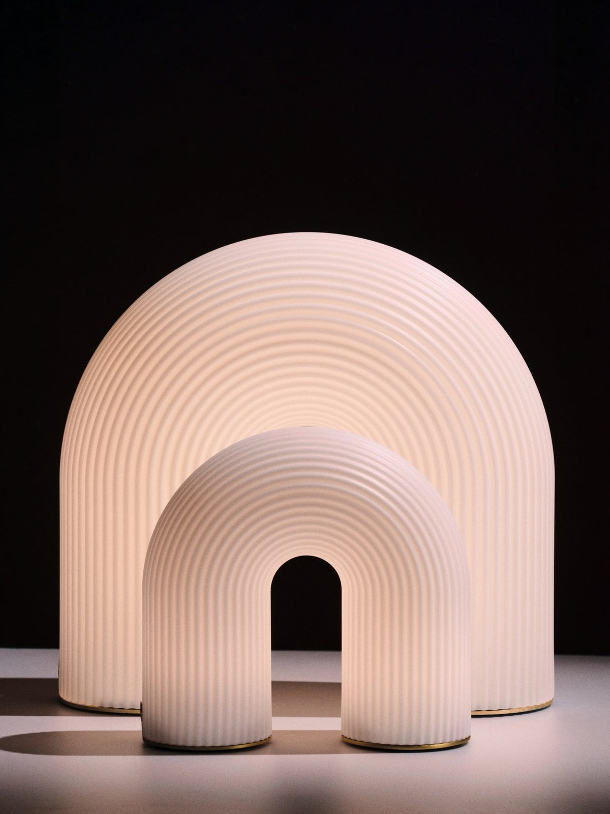 Weisse tragbare Tischleuchte Vuelta H25 von Ferm Living mit bogenförmigem Design aus HDPE-Basis und vernickelten Stahlfüssen, ohne sichtbares Kabel.