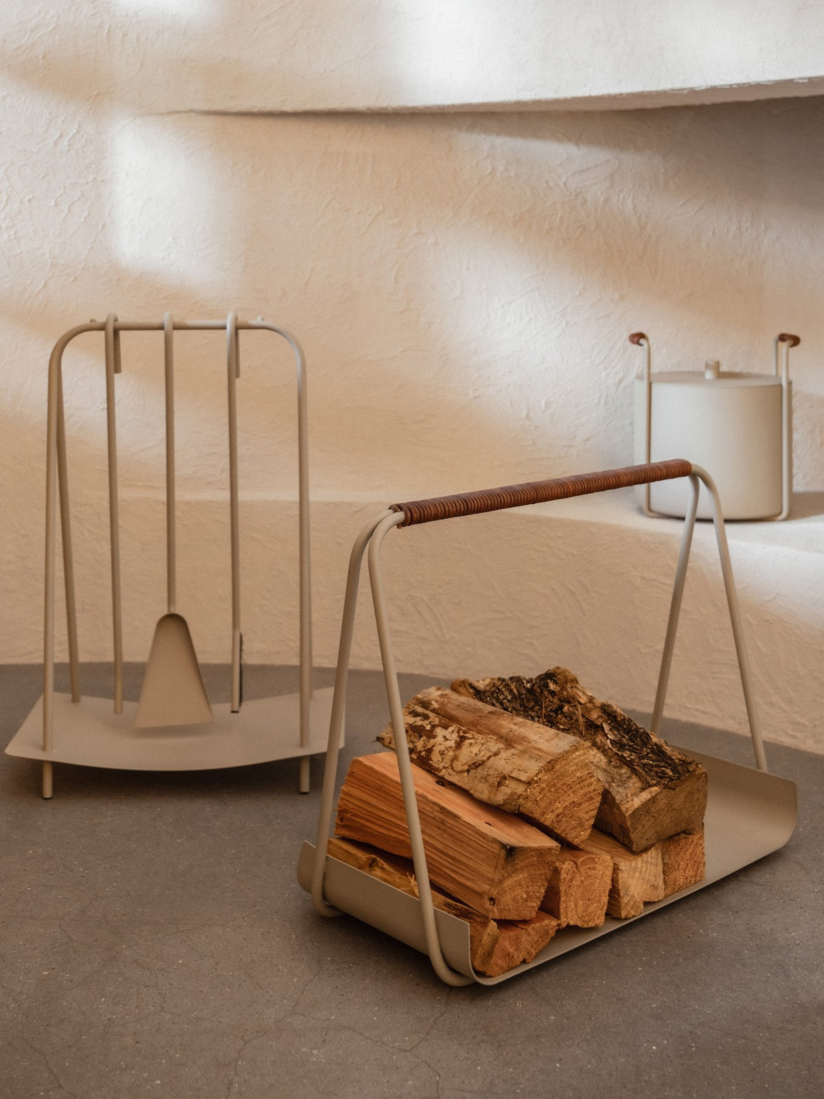 Port Brennholzregal von Ferm Living: pulverbeschichteter Metallkorb in Cashmere mit abgerundeten Kanten und lederbezogenem Griff.