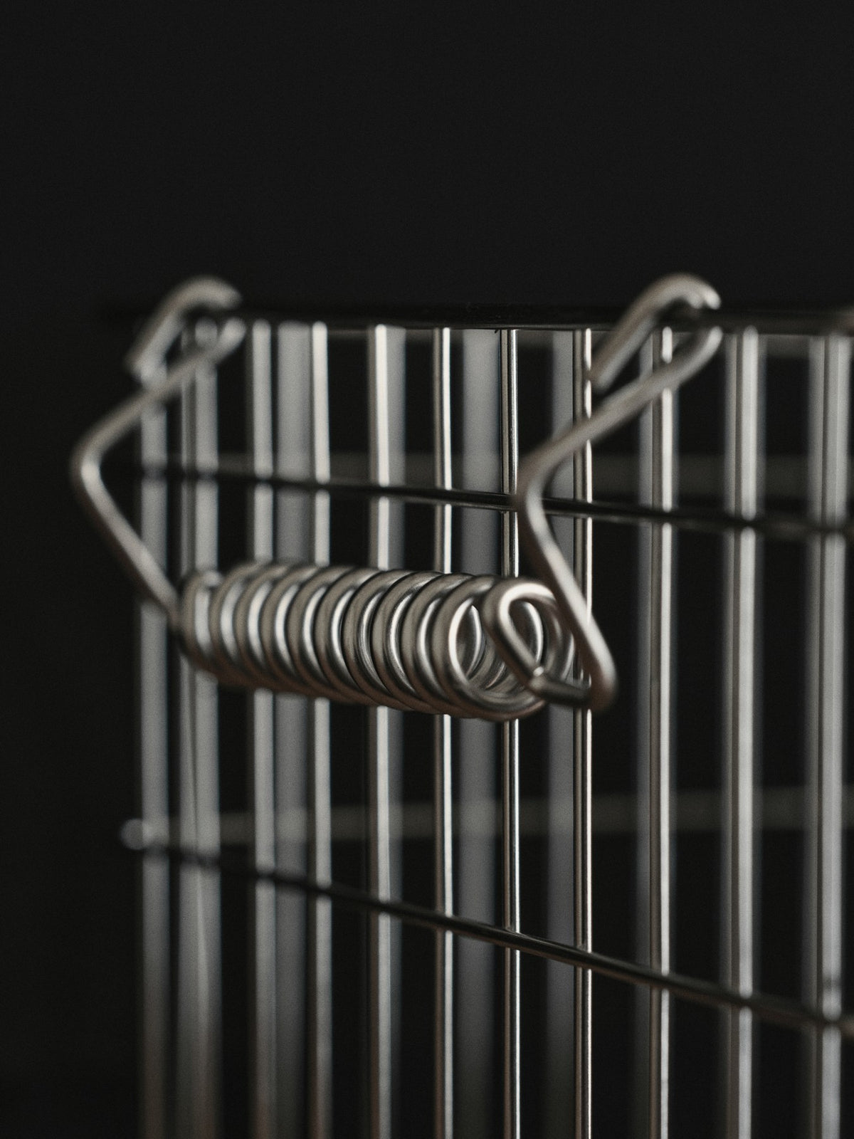 Zwei offene stapelbare Aufbewahrungskörbe aus Edelstahl mit Spiralgriff und Frontöffnung, Ferm Living Cala Serie, Höhe 13 cm.