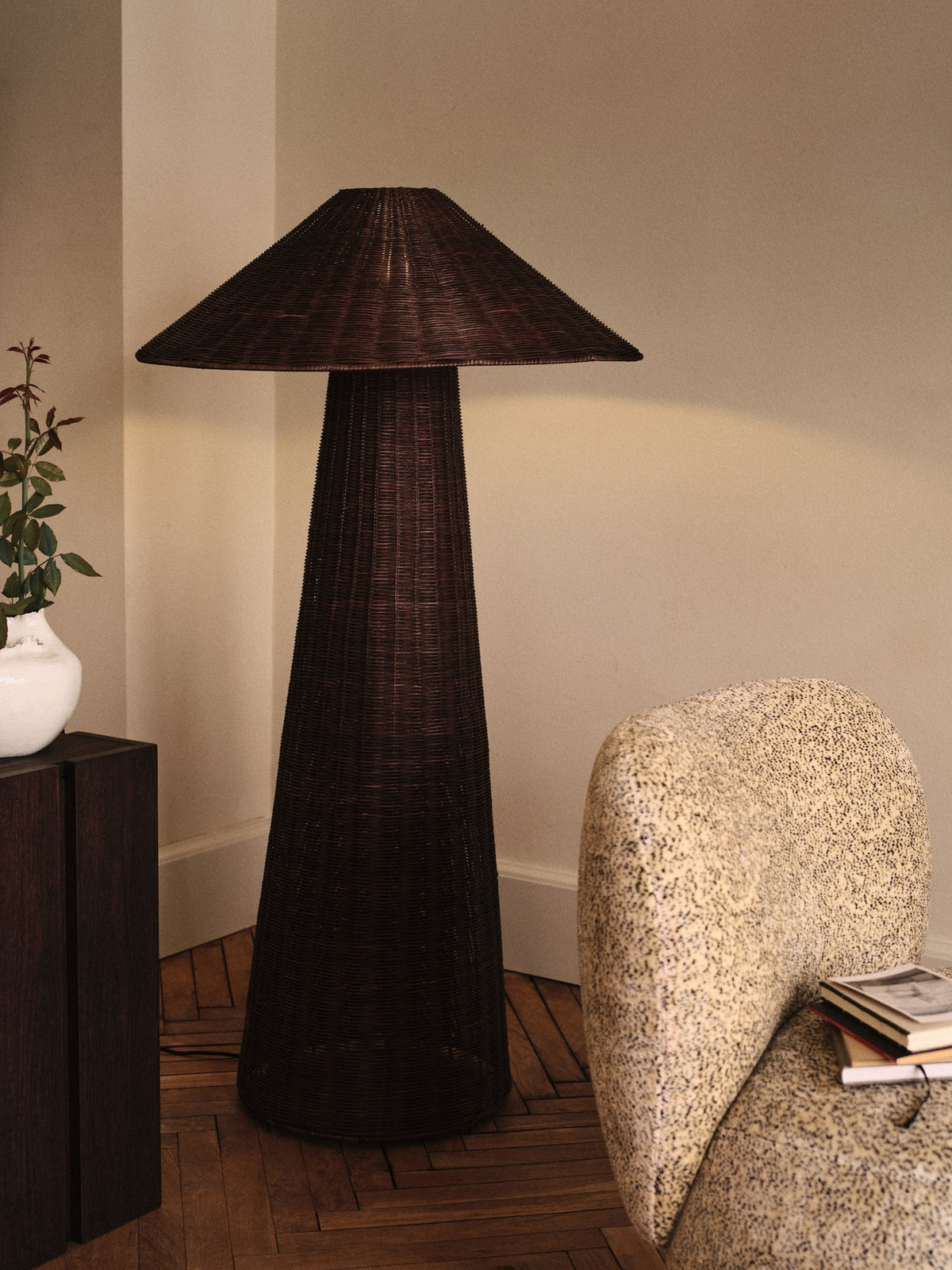 Dou Stehleuchte von Ferm Living mit rundem, handgeflochtenem Lampenschirm aus dunkelbraunem Rattan auf schlankem Eisensockel.