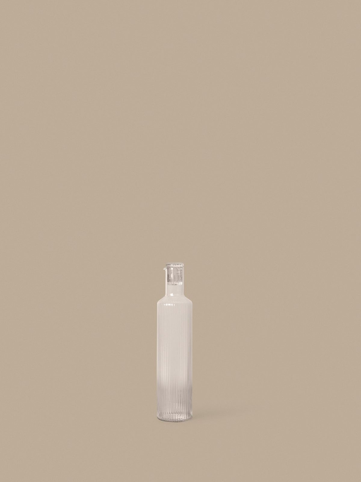Klare, mundgeblasene Glasflasche mit geriffelter Oberfläche und geometrischer Form, schlanker Hals mit Deckel, aus der Ripple-Serie von Ferm Living.