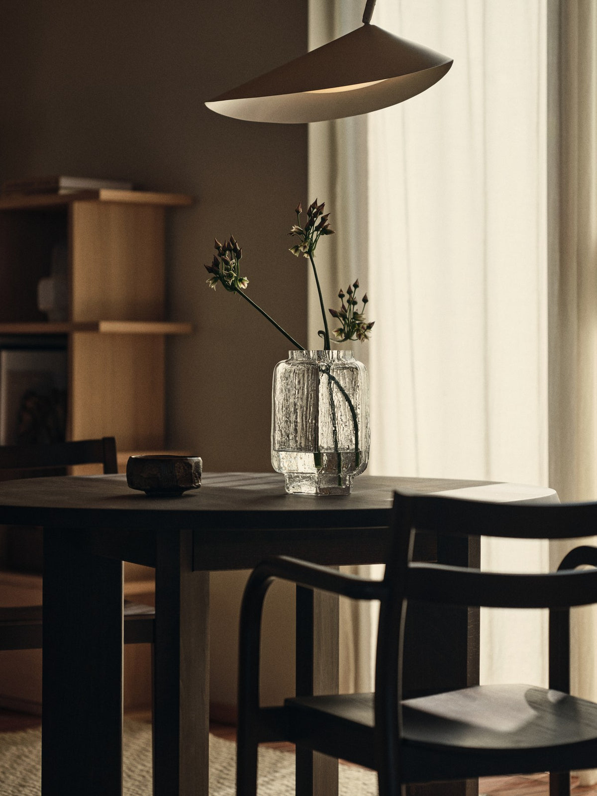 Schwarze Arum Bogenstehleuchte von Ferm Living mit massivem Marmorsockel, gebogenem Aluminium-Lampenschirm und Stoffkabel.