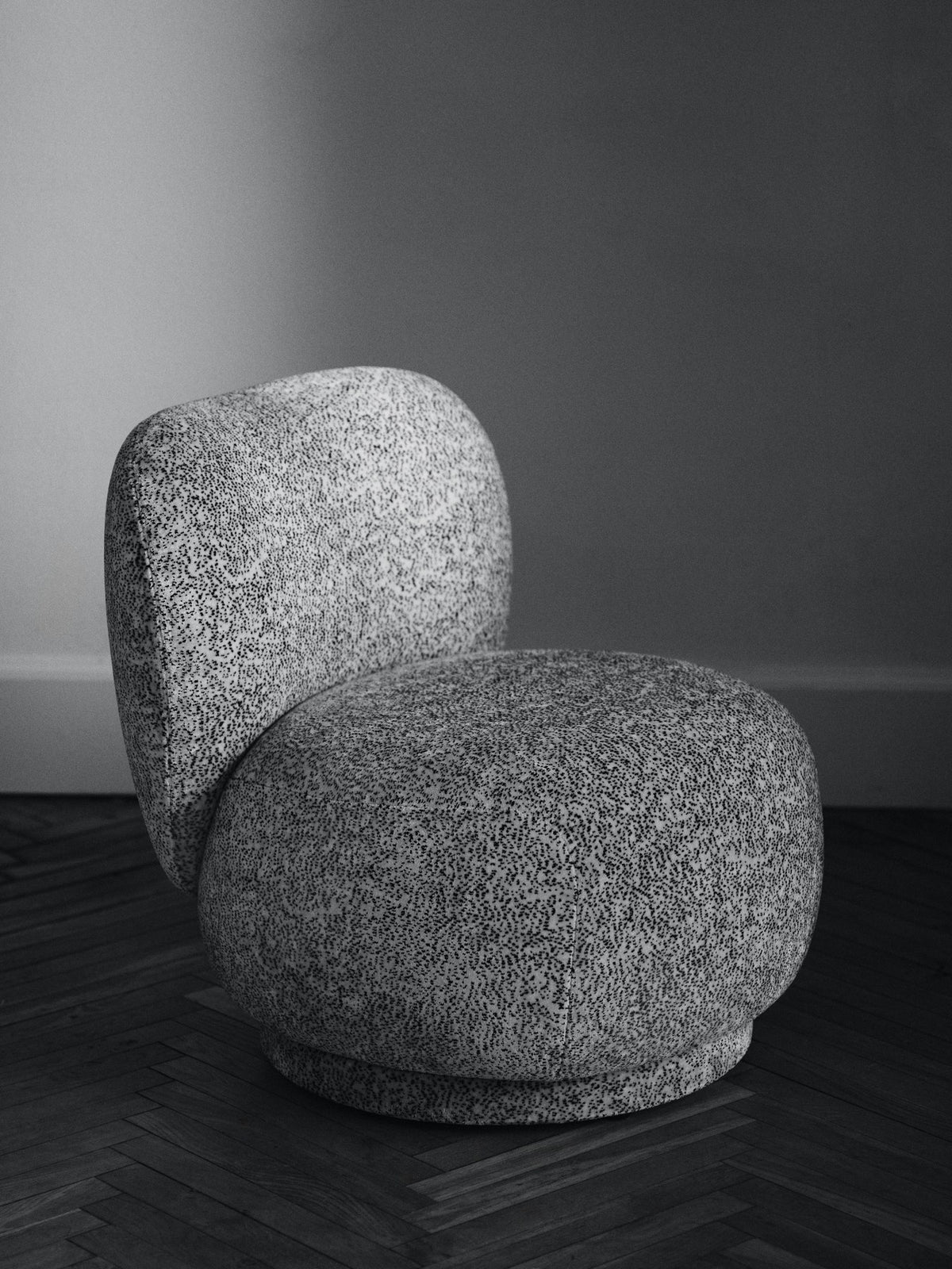 Foto eines Drehsessels Rico Lounge Piccolo von Ferm Living mit Bezug aus Poppy Velvet in Butter/Black, kompakte runde Form und Drehsockel.