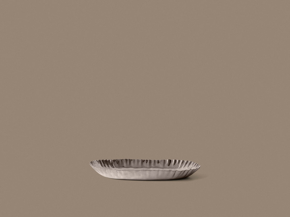 Poliertes Edelstahl-Tablett Tydra von Ferm Living mit geschwungener, wellenförmiger Form und glänzender Oberfläche, Grösse 24.5 x 34.5 x 3.5 cm.