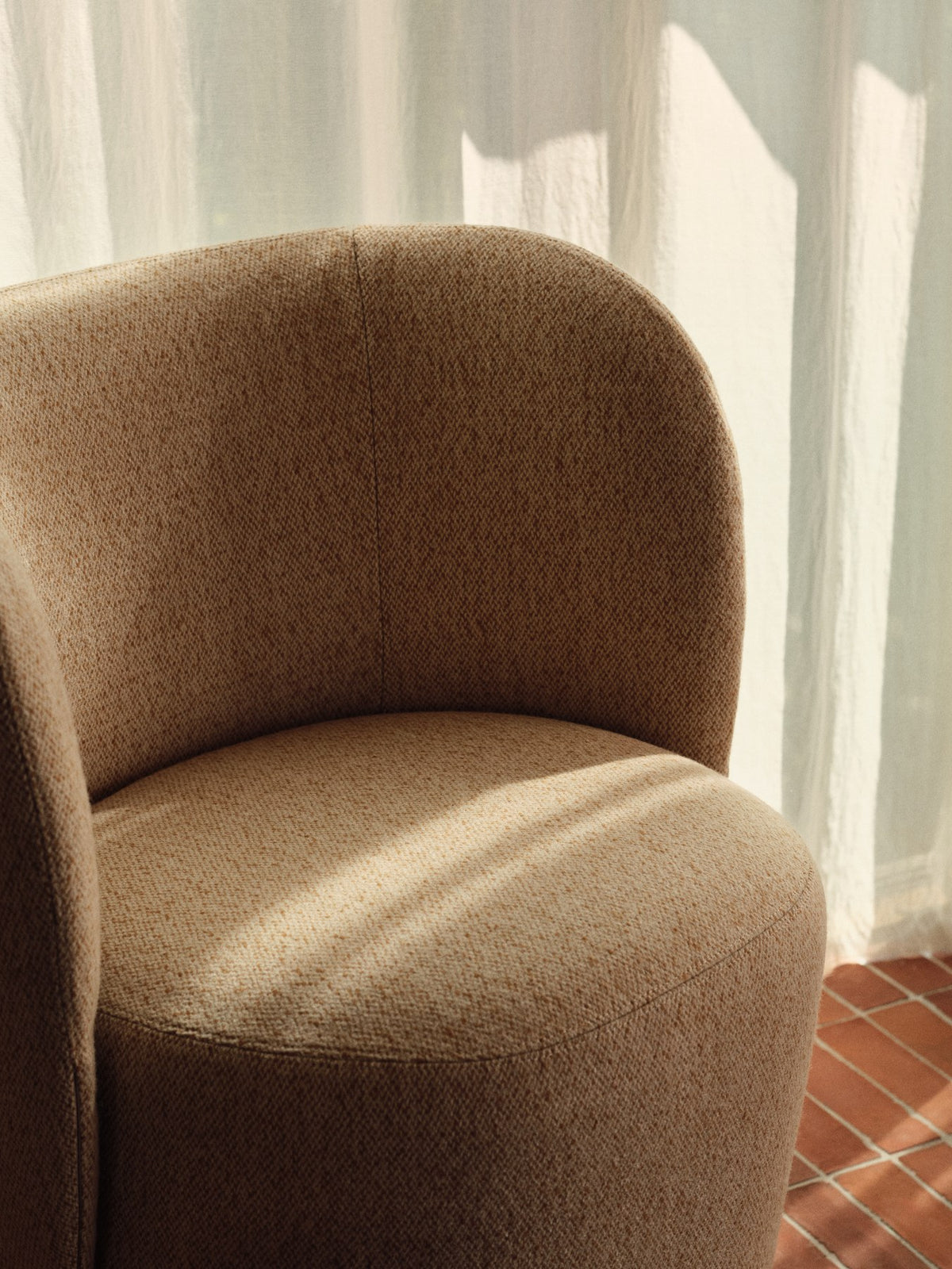 Rico Club Drehsessel von Ferm Living in Off-White/Honig, Bezug aus Kammgarnwolle und Nylon, geschwungene Form mit Drehfuss aus Polyethylen.