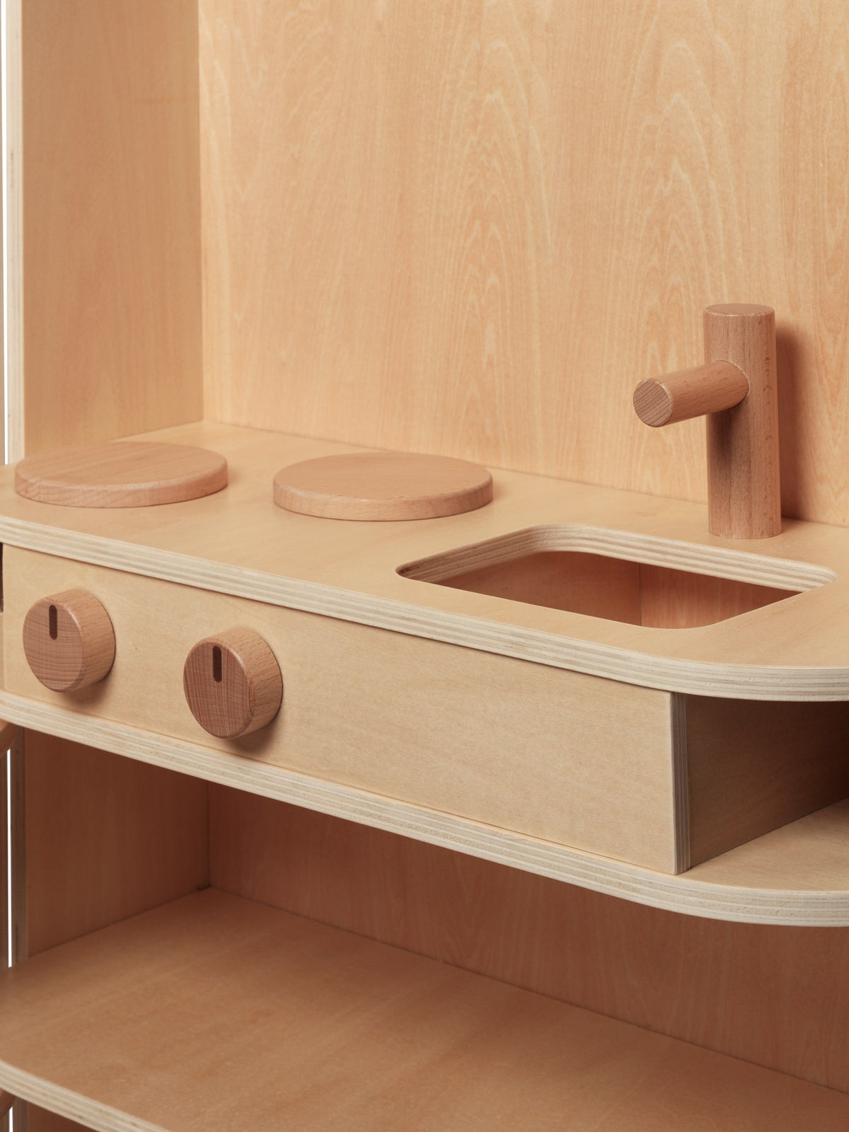 Kinderspielküche Toro von Ferm Living aus Natur-Sperrholz mit Buchendetails, Schiebetür, Wasserhahn und klappbarem Aufbau.