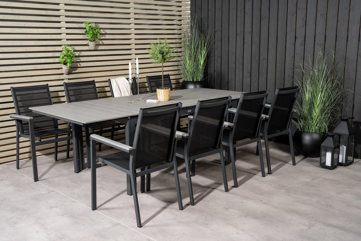 Rechteckiger Esstisch aus Aintwood mit Aluminiumgestell in Anthrazit, dazu zwei stapelbare Stühle mit pulverbeschichteter Oberfläche.