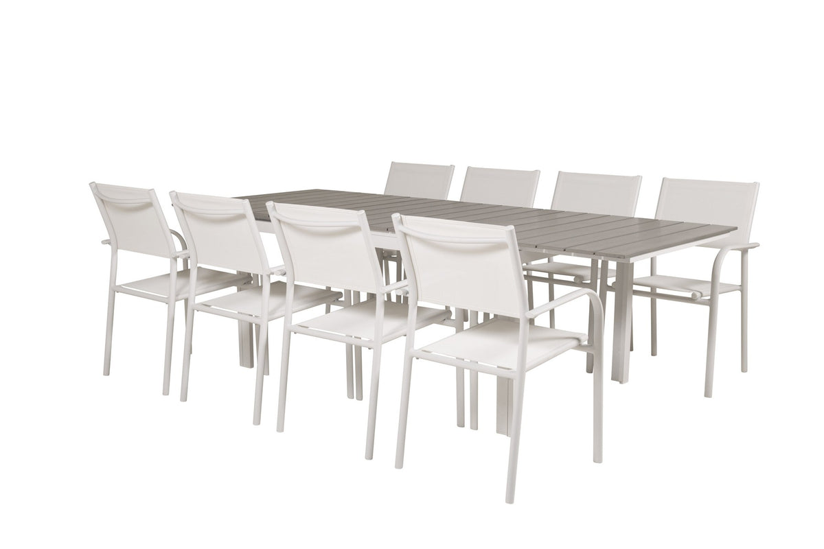Ausziehbarer Gartentisch mit grauer Aintwood-Tischplatte und Aluminiumbeinen, umgeben von sechs weissen, stapelbaren Santorini Stühlen aus Aintwood und Aluminium.