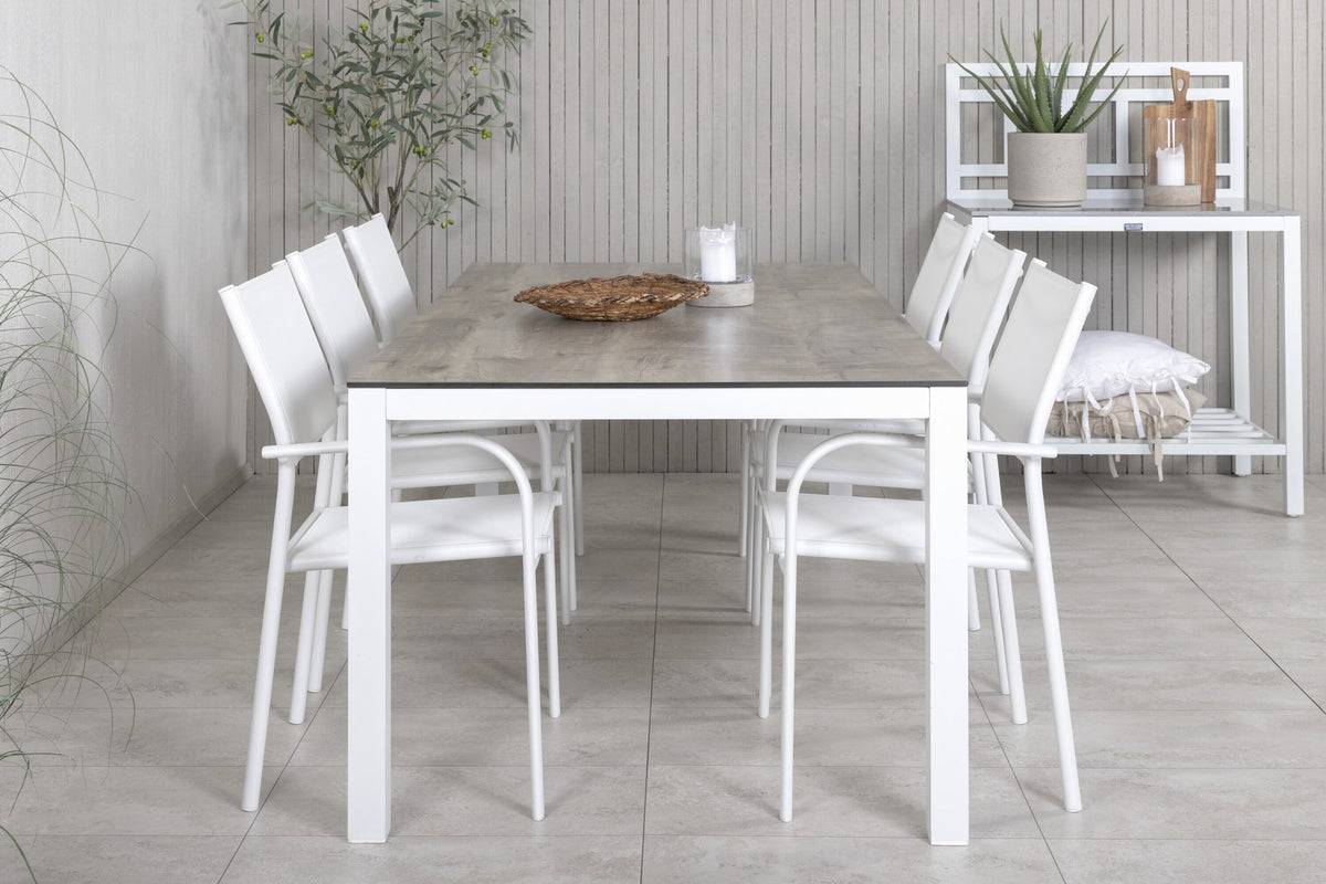 Zwei weisse Aluminium-Stühle mit Pulverbeschichtung und ein rechteckiger Esstisch mit grauer HPL-Tischplatte der Serie Santorini & Llama.