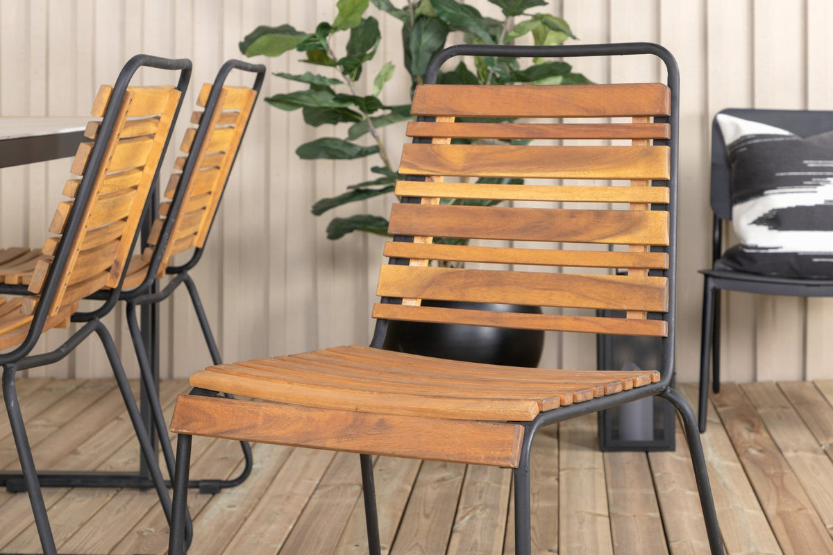 Rechteckiger Gartentisch mit schwarzer Glasplatte und Teakholz-Elementen, dazu zwei Esszimmerstühle mit Teakholz-Optik und Stahlgestell im Freien.