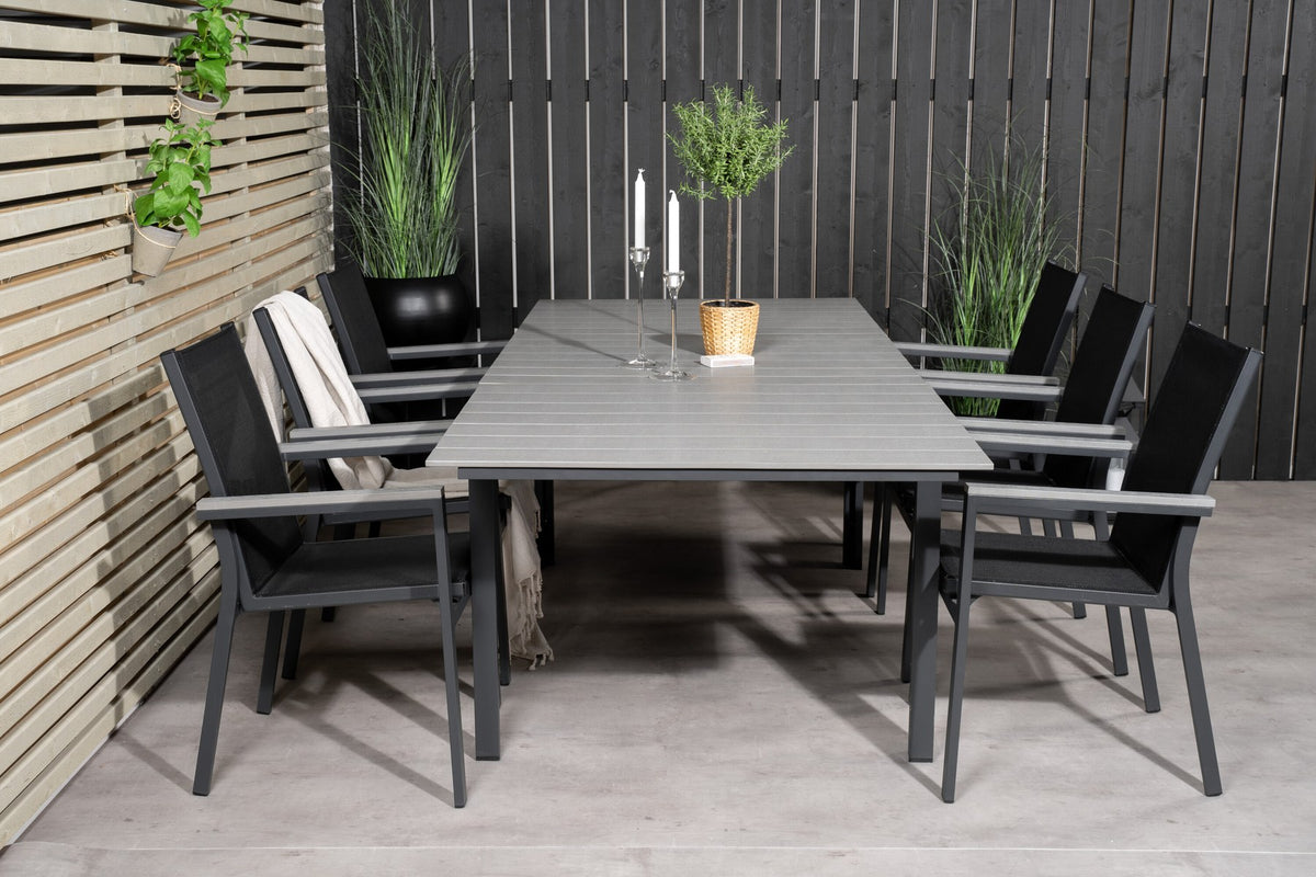 Rechteckiger Esstisch aus Aintwood mit Aluminiumgestell in Anthrazit, dazu zwei stapelbare Stühle mit pulverbeschichteter Oberfläche.
