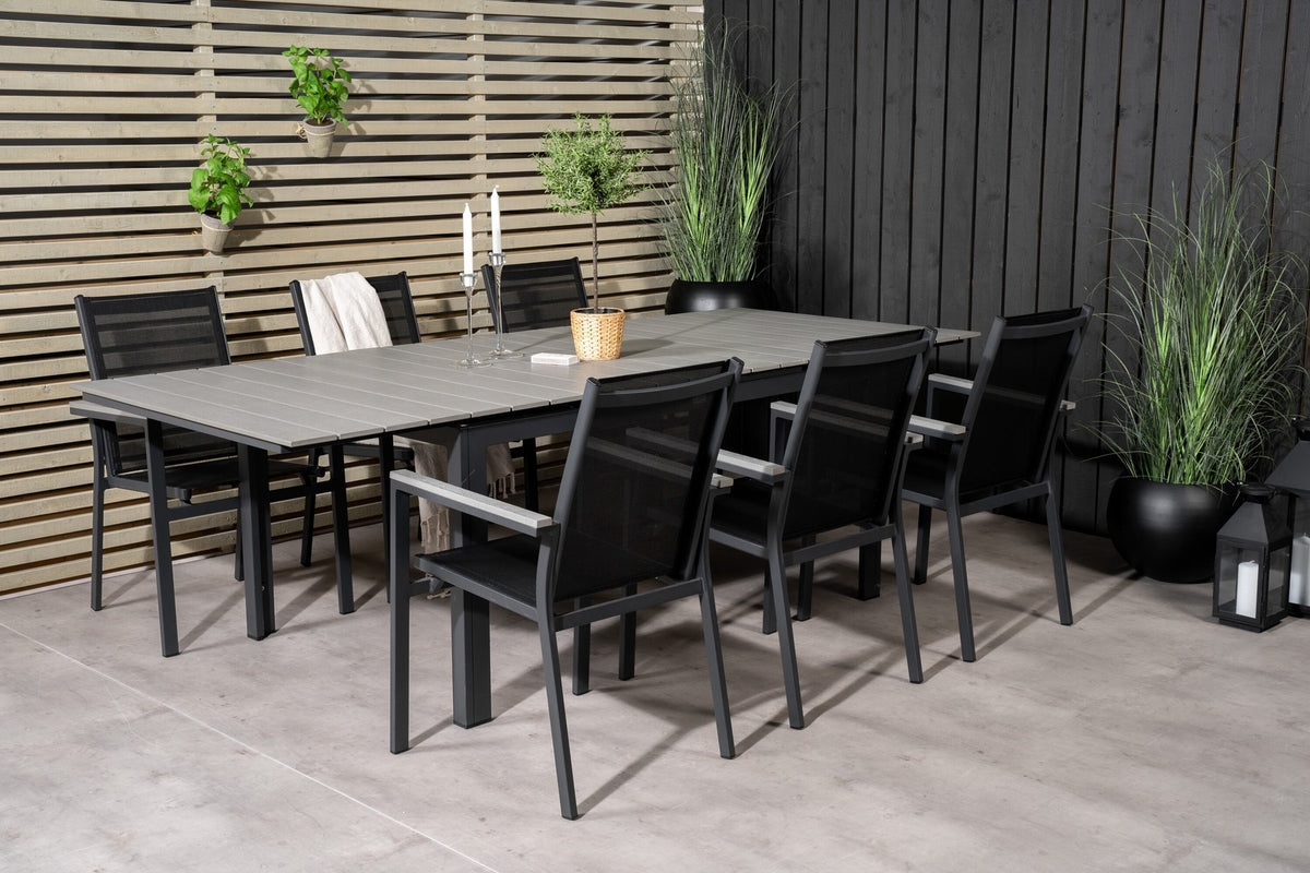 Rechteckiger Esstisch aus Aintwood mit Aluminiumgestell in Anthrazit, dazu zwei stapelbare Stühle mit pulverbeschichteter Oberfläche.