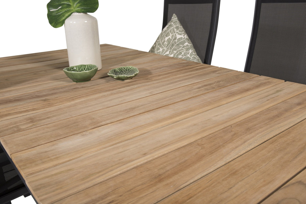 Zwei schwarze Relaxsessel Copacabana aus Aluminium mit Pulverbeschichtung neben rechteckigem Teak-Esstisch Mexico in Natur, Gartenmöbel-Set.
