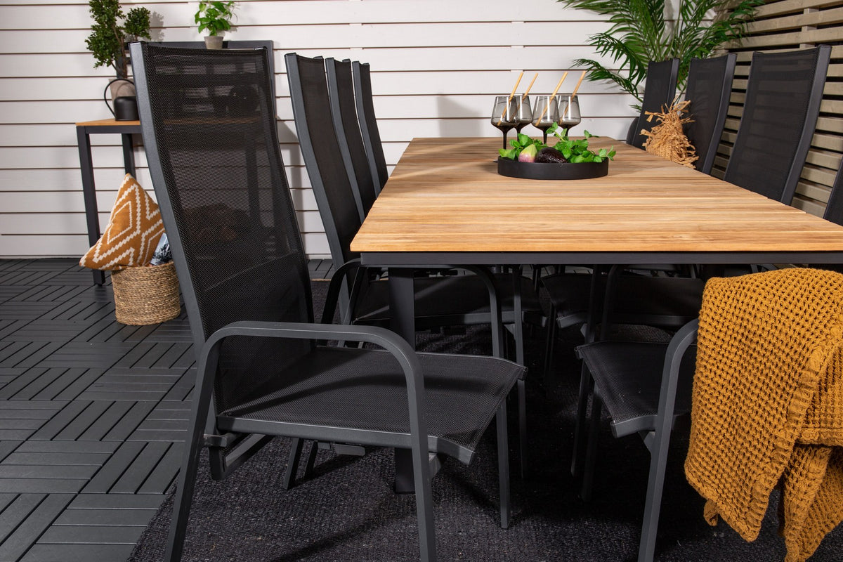 Zwei schwarze Relaxsessel Copacabana aus Aluminium mit Pulverbeschichtung neben rechteckigem Teak-Esstisch Mexico in Natur, Gartenmöbel-Set.