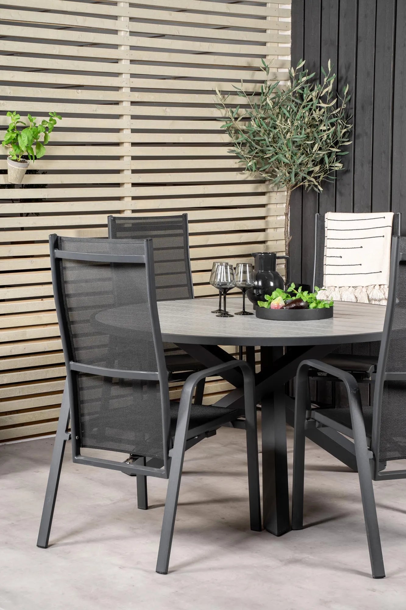 Elegantes Parma Tischset: Runde Form, Aintwood-Tisch, graue Seilstühle – ideal für stilvolle Outdoor-Momente.