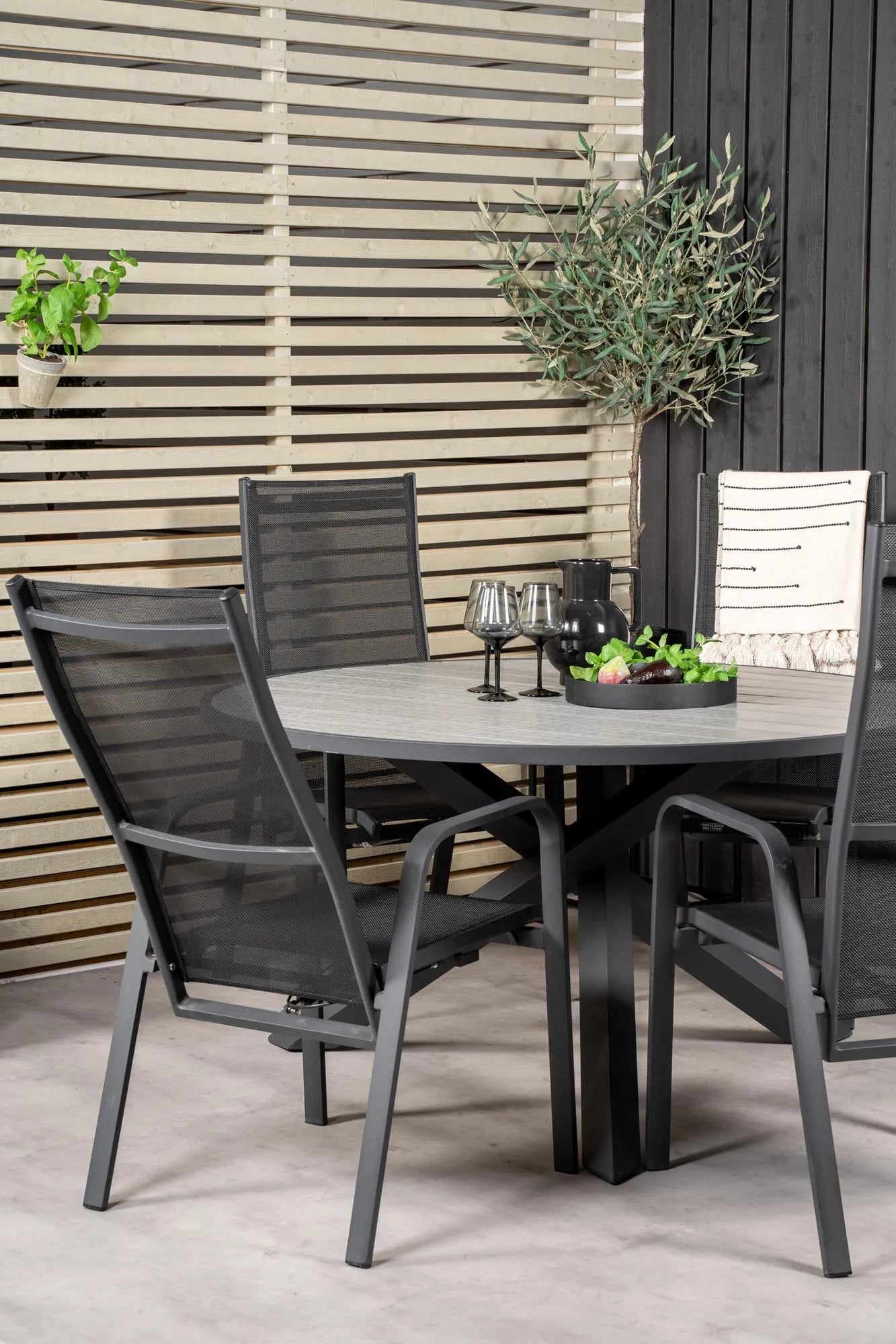 Elegantes Parma Tischset: Runde Form, Aintwood-Tisch, graue Seilstühle – ideal für stilvolle Outdoor-Momente.