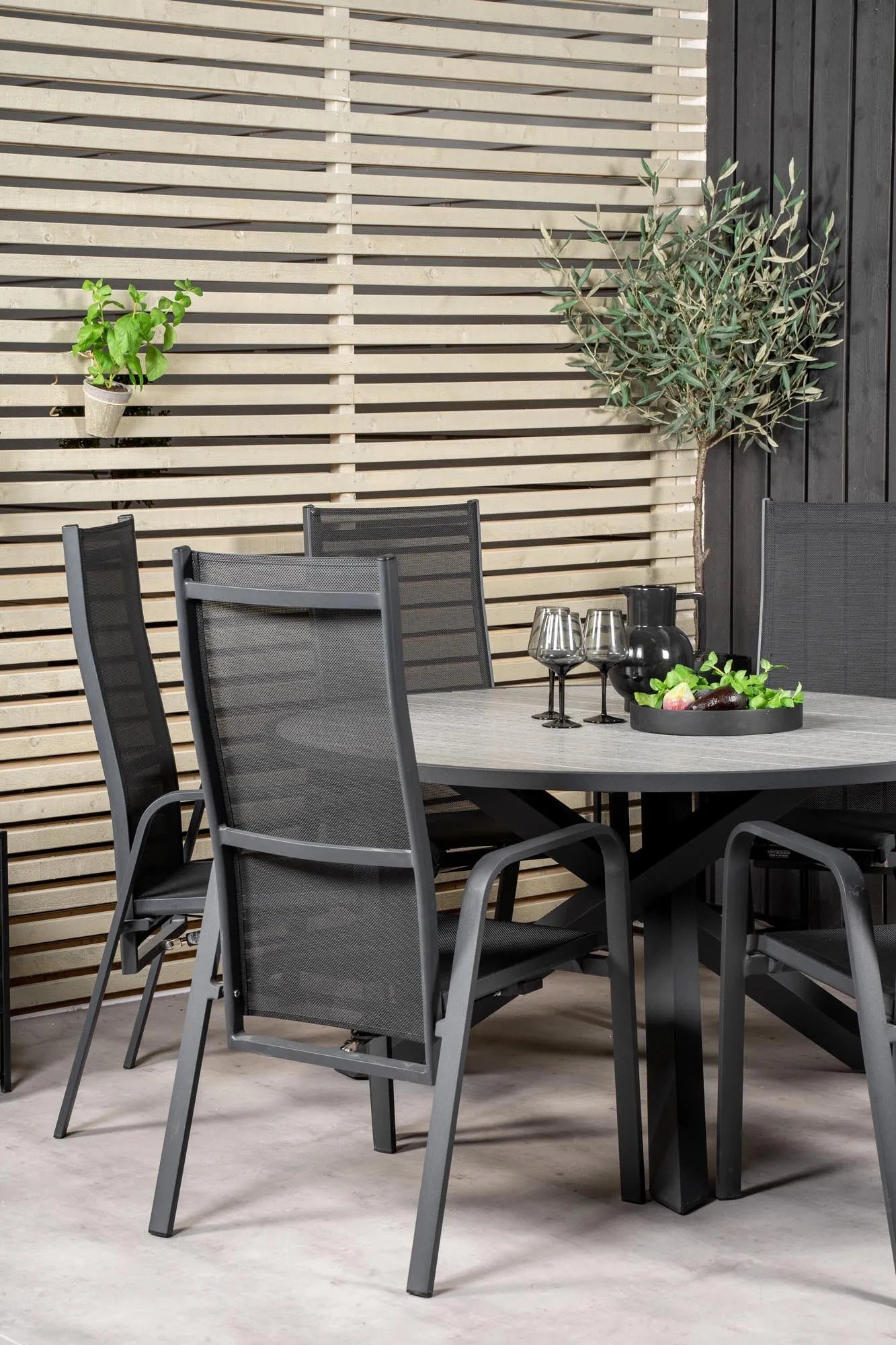 Elegantes Parma Tischset: Runde Form, Aintwood-Tisch, graue Seilstühle – ideal für stilvolle Outdoor-Momente.