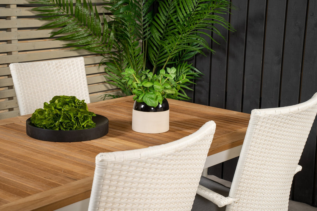 Zwei weisse Stapelstühle Anna und ausziehbarer Teak-Esstisch Panama mit Aluminium- und Stahlgestell, rechteckige Tischplatte in Naturholz-Optik.