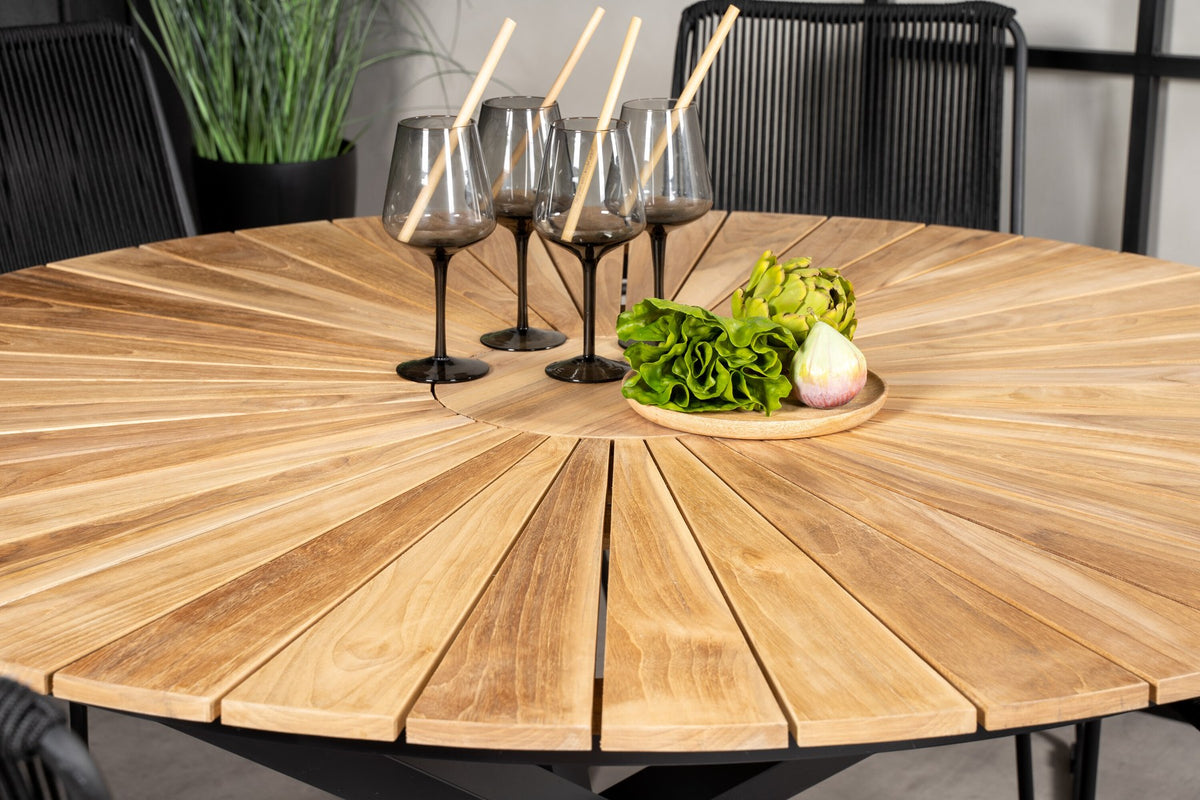 Runder Gartentisch mit Teak-Tischplatte in Naturfarbe, Stahlbeinen und Stühlen mit schwarzer Seilbespannung im Aussenbereich.