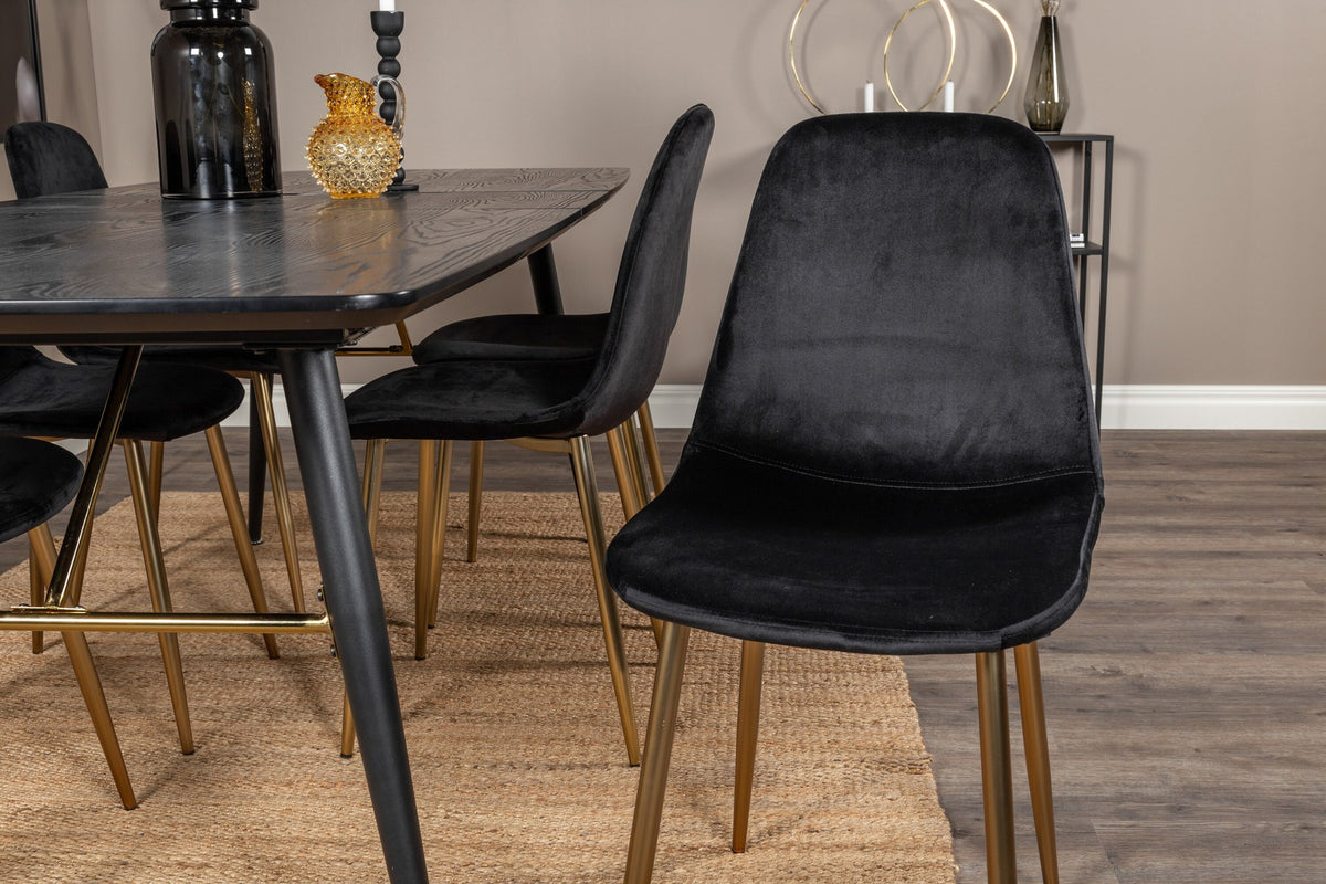 Rechteckiger Esstisch mit schwarzer MDF-Tischplatte und Stahlgestell, dazu zwei schwarze Esszimmerstühle mit gepolsterter Sitzfläche.