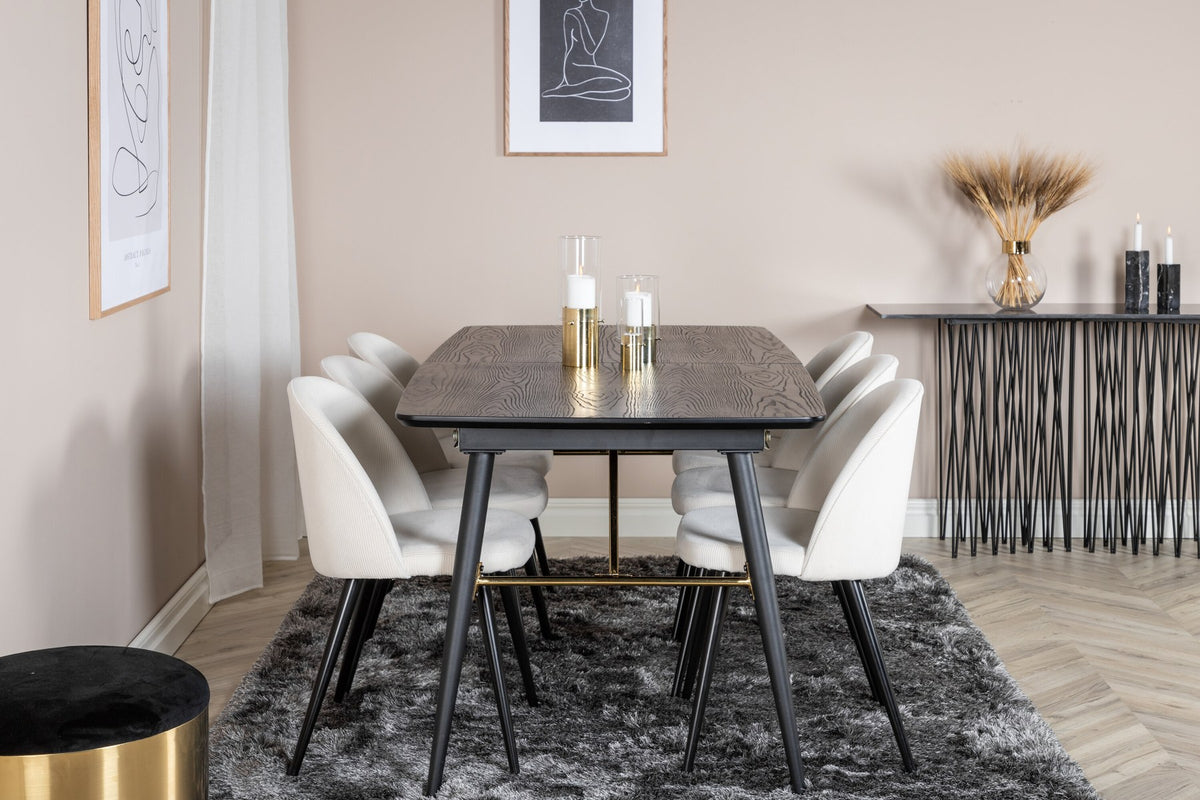 Rechteckiger Esstisch mit schwarzer MDF-Platte und Stahlbeinen, daneben zwei gepolsterte Esszimmerstühle in Creme mit Stahlgestell.